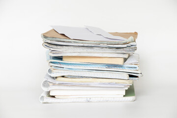 A stack of old notebooks, notepads and books on a white background, a symbol of study, education and work