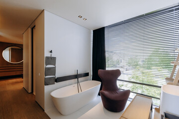 A bathroom equipped with both a comfortable bathtub and a chair for relaxation