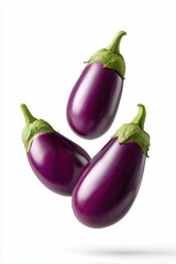 Three glossy purple eggplants floating in mid-air on white
