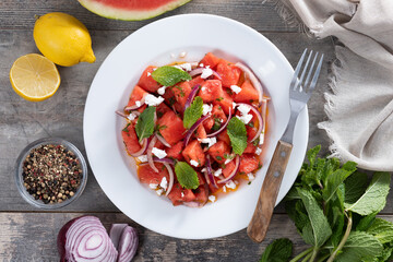 Fresh Watermelon Feta Salad with Mint and Red Onion on wooden table