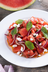 Fresh Watermelon Feta Salad with Mint and Red Onion on wooden table