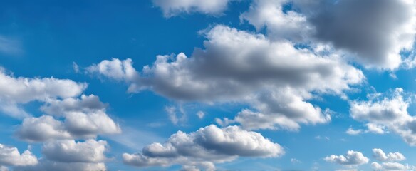 Fototapeta premium The serene beauty of fluffy clouds against a bright blue sky.