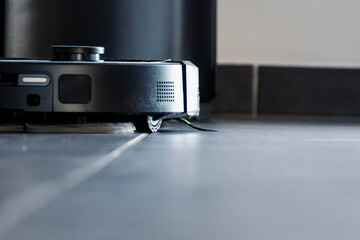 Robot vacuum cleaner with dust, real life photo, saves time and goes into hard-to-reach places