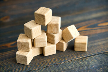 Collapsing pyramid of natural wooden cubes