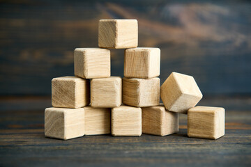 Collapsing pyramid of natural wooden cubes