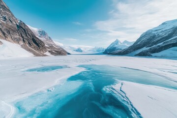 Icy landscape with glacial lake and towering mountains under a clear blue sky in a remote location