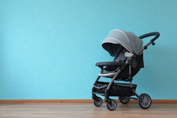 Grey stroller against a light blue wall on a wood floor