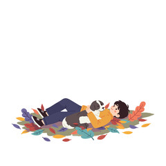 Fototapeta premium Boy lying in leaves with dog and smiling in autumn scenery 