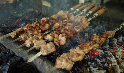 Grilling shashlik on metal skewers on grill, barbecue grill over charcoal