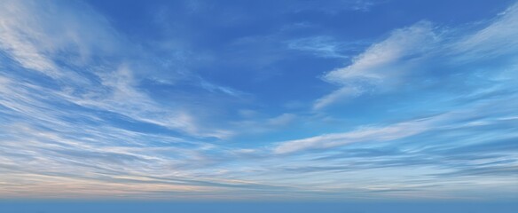 The expansive blue sky with soft clouds at sunset over a tranquil landscape.