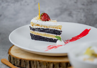 A beautifully decorated slice of cake with creamy layers and toppings. Perfect for dessert menus,...