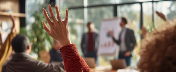 The raised hand signals engagement in a dynamic business meeting or workshop setting.