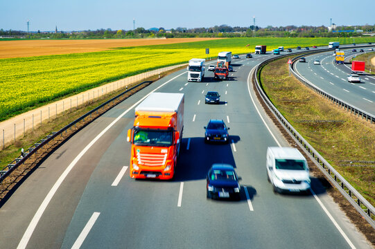 Trucks and cars on the A44 highway in J�chen, Germany with motion blur and a rape field in the background