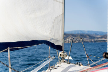 Sailboat sailing in the sea with coastline in background