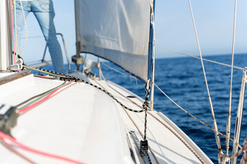 Sailor navigating sailboat on open sea during sunny day
