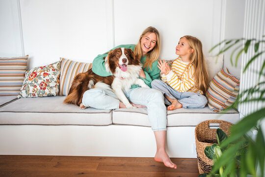 Mother and daughter enjoying time with their dog at home