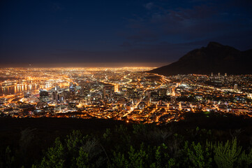 Cape Town glowing at night seen from Signal Hill with Table Mountain in the background