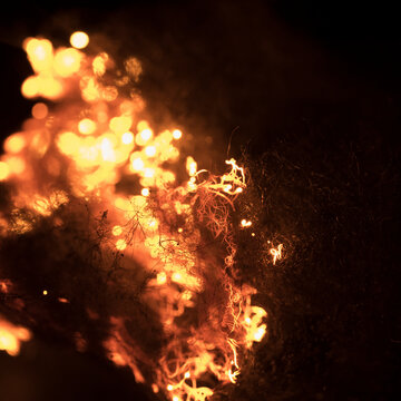 Bright sparks fly as steel wool is ignited in darkness