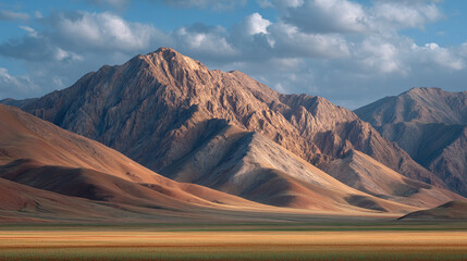 Mountain range under cloudy sky with warm evening shadows, dramatic landscape scenery in soft light for travel or nature themed background