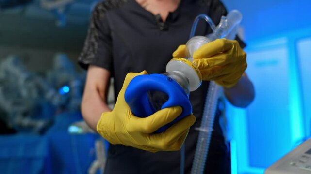Oxygen mask is assembled by the unrecognized female medic. Medical equipment is prepared for operation. Close up. Blurred backdrop.