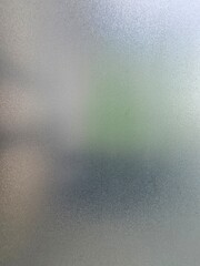Textured frosted window glass with soft gradient light , abstract blurred glass surface background 