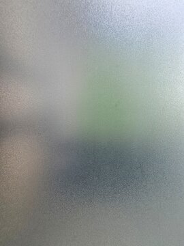 Textured frosted window glass with soft gradient light , abstract blurred glass surface background 