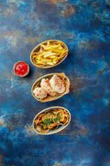 Various types of snacks, French fries, chips, cauliflower in spices and tomato sauce