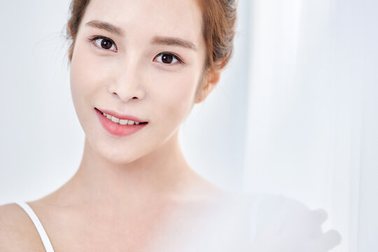 Young Asian Woman in White Tank Top with Hand Raised, Minimalist Natural Light Portrait