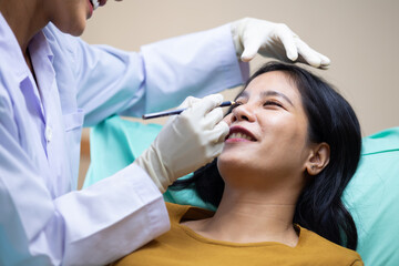 Fototapeta premium Facial aesthetics surgery treatment : Plastic (Cosmetic) Surgery Center : Brazilian hispanic female Doctor preparing Asian female patient for cosmetic surgery in clinic