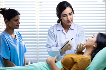 Fototapeta premium Facial aesthetics surgery treatment : Plastic (Cosmetic) Surgery Center : Brazilian hispanic female Doctor preparing Asian female patient for cosmetic surgery in clinic