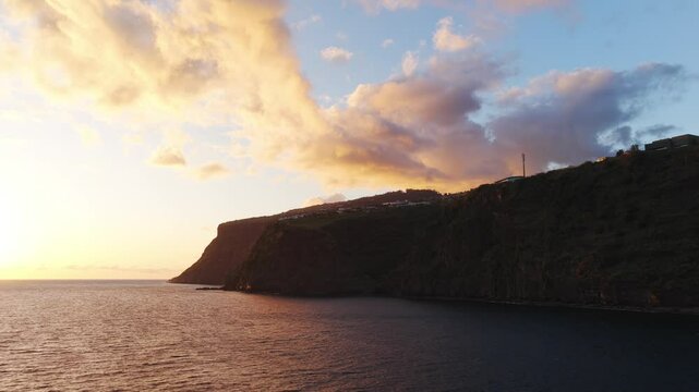Sunset illuminating Calheta coastline cliffs in Madeira Island, Portugal, with warm golden colors