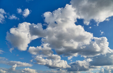 Bright white cumulus clouds illuminated by sunlight create a sense of lightness and tranquility. For use in nature and travel materials.