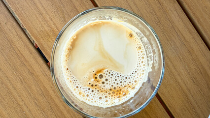 Effervescent latte topography swirls in a glass, invoking National Coffee Day zen, echoing hygge...