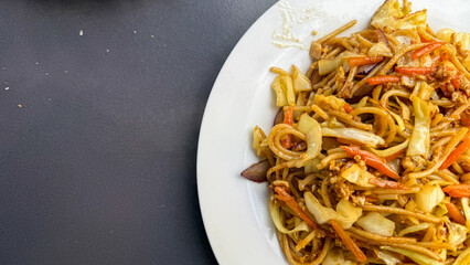 Stir-fried noodles dance with vibrant vegetables, evoking Lunar New Year warmth and Diwali's delightful culinary tapestry, tasty harmony