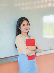 Chinese student teacher enjoying smile standing in classroom at kids school. Asian school and teacher woman. Female Teacher teaching students learning development. Education knowledge 