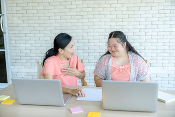 Caring mother guiding her young daughter in using the internet properly on a computer, family learning and online safety concept