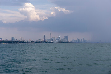 Naklejka premium Thailand.Pattaya. View of the city in cloudy weather from the ship at a distance from the shore
