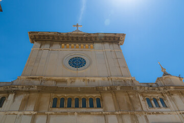 Positano, Italy the intricate details of Santa Maria Assunta historic church facade,  showcasing stunning architecture against a vibrant blue sky.