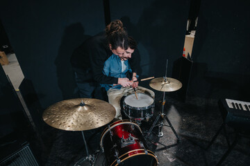 Musicians rehearsing together during a practice session, focusing on drumming technique and rhythm...
