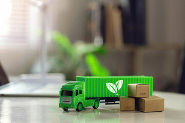 Green logistics or Sustainable global transport. Sustainable logistics.Green container trucks and parcels, eco-friendly packaging on the desk.Transport Management System technology for clean energy.
