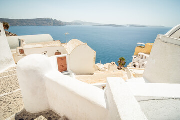 Fototapeta premium numerous houses and fences on the cliff of Santorini island. Oia village in the foreground and Cyclades islands in the background.