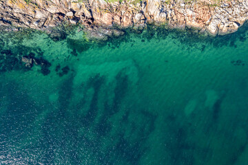 rocky shore and turquoise water sea, aerial top down drone view. Summer background concept texture