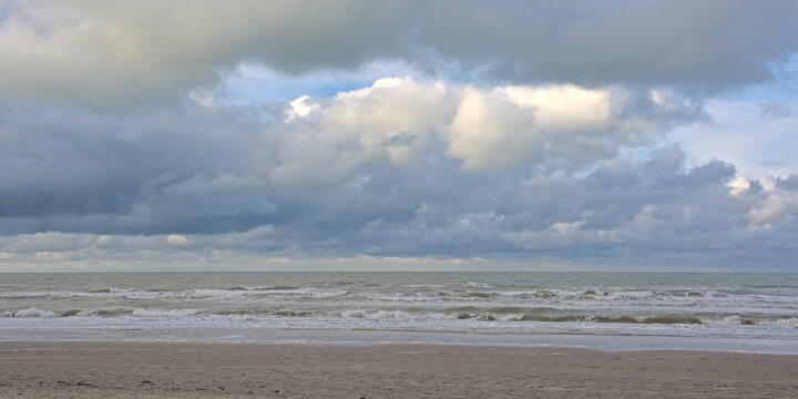 North sea beach with dark stomy clouds in De Panne, Flanders, Belgium 