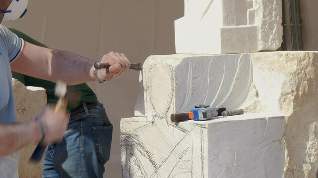 Sculptor's hands working on a white stone block, carving a human figure with chisel and hammer. Captures artistry, craftsmanship, and creation process.