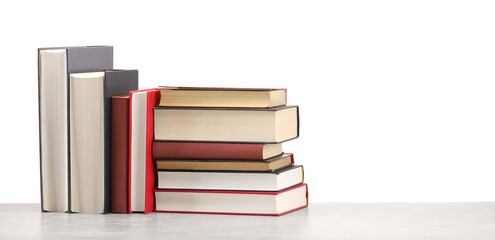 Old books on light grey table against white background