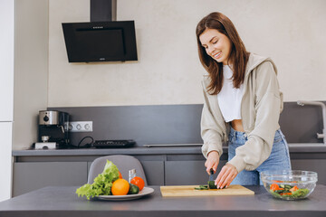 Young Woman Cutting Vegetables, Preparing Healthy Meal in Modern Kitchen