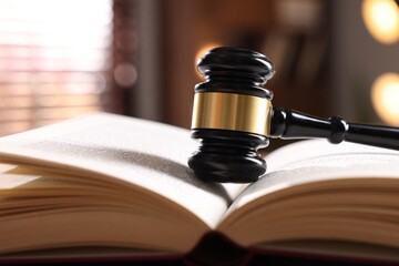 Judge's gavel on book against blurred background, closeup