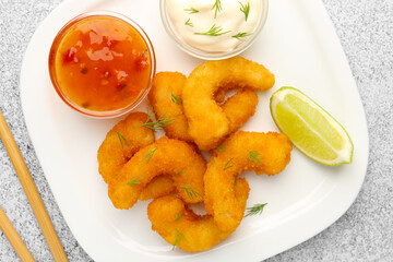 Tasty tempura shrimps, lime and sauces on grey textured table, flat lay