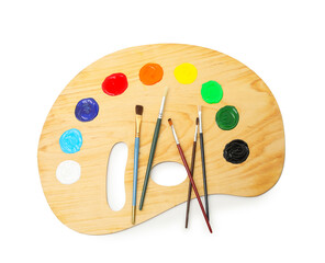 Wooden palette with paints and brushes isolated on white, top view