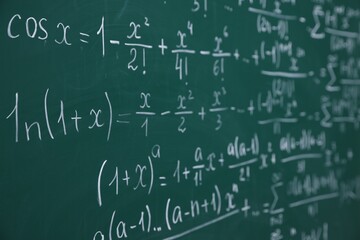 Different formulas written with chalk on blackboard, closeup